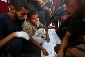 mourners gather over a body in a shroud