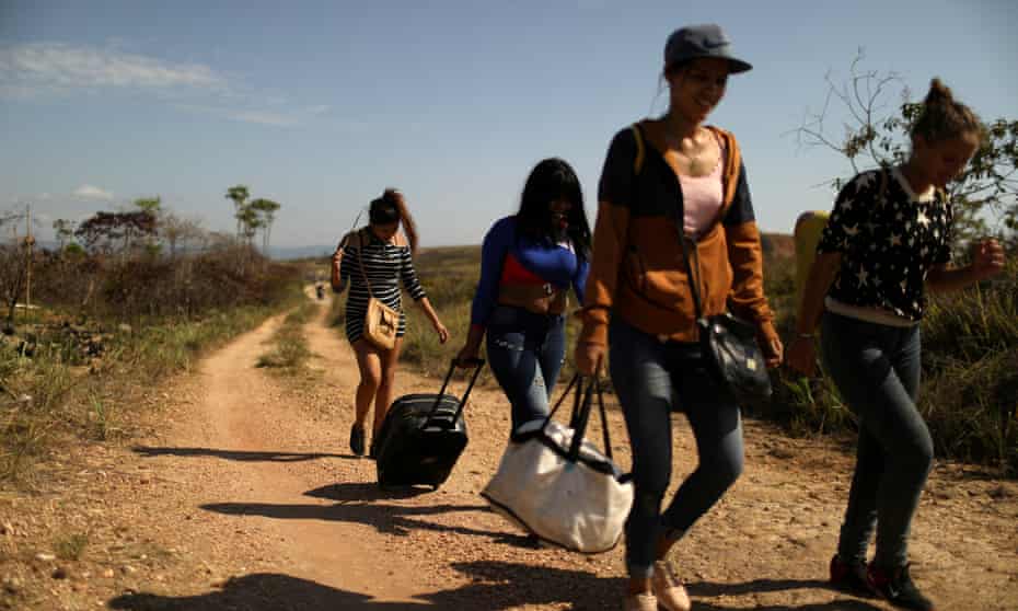 Venezuelan migrants walk along a trail into Brazil, at the border city of Pacaraima, Brazil, on 11 April 2019.
