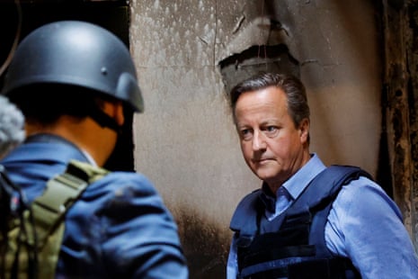 British foreign secretary David Cameron walks inside a damaged building during his visit to kibbutz Be’eri.