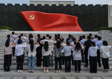 People say an oath of loyalty in front of a flag of the Communist party of China on the 105th anniversary of its founding in Beijing in July.