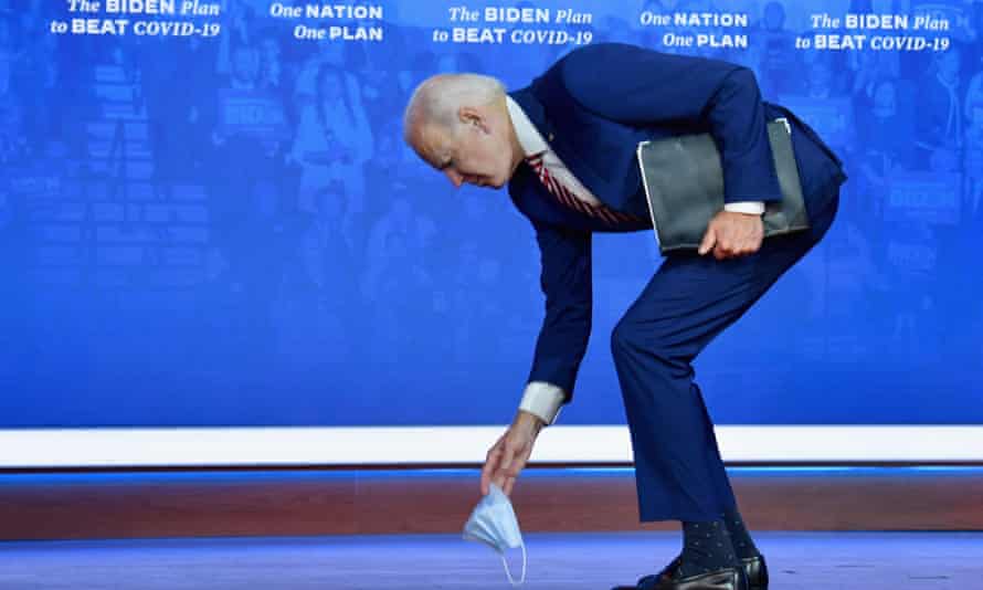Democratic presidential nominee and former Vice President Joe Biden picks up his mask after dropping it at the end of his speech on Covid-19 at The Queen theater on October 23, 2020 in Wilmington, Delaware.