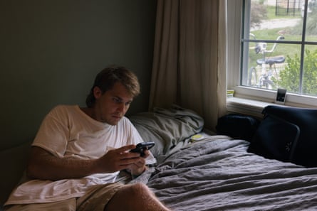 A man on his phone on his bed