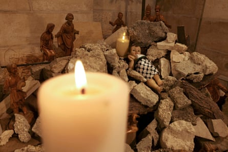 A scene of the nativity of Christ with a figure of baby Jesus lies swaddled in a keffiyeh, half buried in a pile of rubble, inside the the Evangelical Lutheran Church in Bethlehem in the occupied West Bank on 6 December.