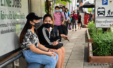 People wait at a bus stop in Bangkok on 18 June 2020.
