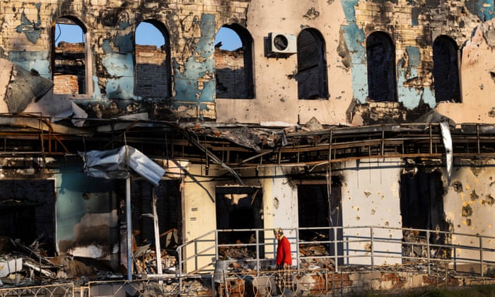 A woman walks by a destroyed building in Izium, Ukraine.