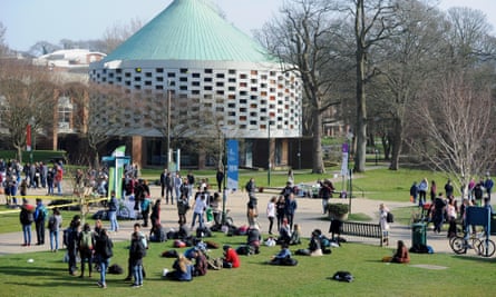 Students at the Falmer campus of Sussex University in Brighton – general view showing modern buildings and grassy areas with students seated and standing in groups