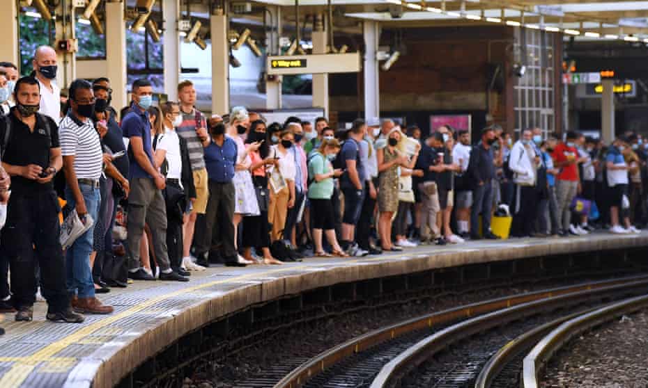 Commuters standing on a station platform.