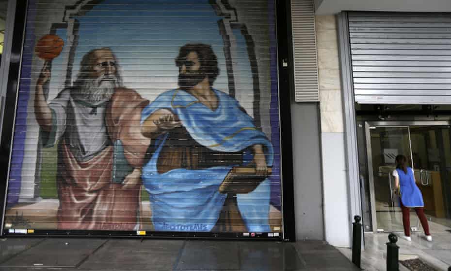Graffiti with the ancient philosophers Plato, left, and Aristotle on the shutter of a cafe in Athens.
