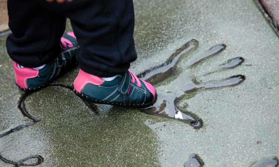 A child dips her shoe in a handprint outside the TLC Chinese Theatre in Los Angeles.