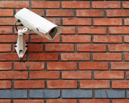 White CCTV camera mounted on a red brick wall