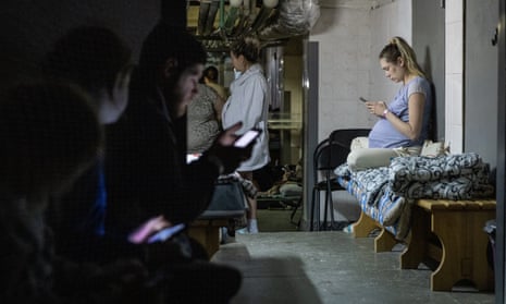 A pregnant woman uses her mobile phone as she rests in the bomb shelter of a maternity hospital  Kyiv, Ukraine