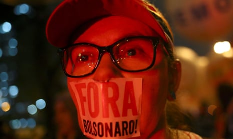 Demonstrator with ‘Out, Bolsonaro’ sticker taped over mouth