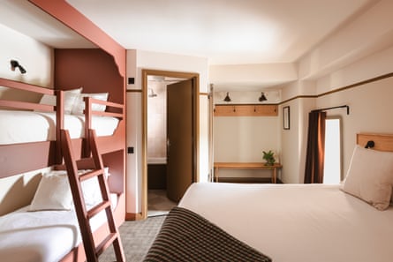 A hotel room with a double bed and bunk beds