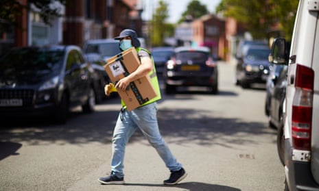 Delivery driver with mask and parcel crossing road