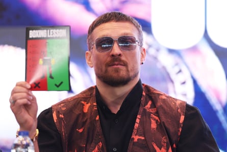 Oleksandr Usyk holds up a ‘Boxing Lesson’ booklet.