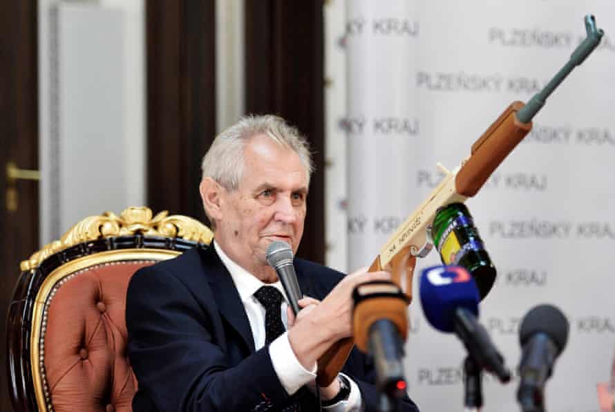 Czech President Miloš Zeman holds a mock assault rifle with “At journalists” inscribed on it in October 2017.