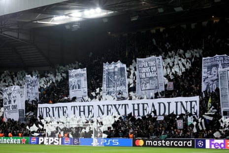 Fans of Newcastle United show their support by displaying a sign that reads' WRITE THE NEXT HEADLINE' alongside banners showing newspaper pages of previous Newcastle United victories in Europe.