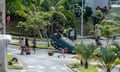People gather near an overturned car in the Motor Pool district on Tuband in Noumea on May 16, 2024,