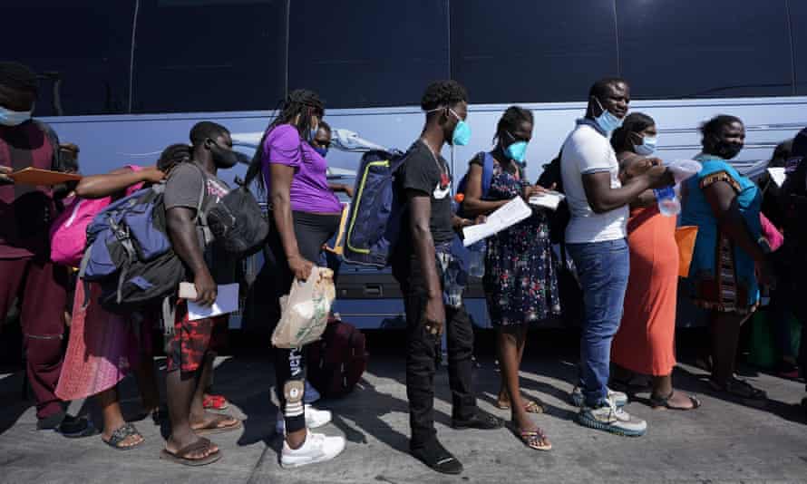 Les migrants, dont beaucoup d'Haïti, montent à bord d'un bus après avoir été traités et libérés après avoir passé du temps dans le camp.