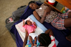 Women and a child rest at a shelter set up at a school