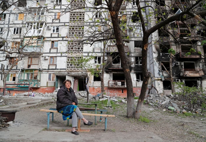 Local resident Tatiana Bushlanova, 64, sits on a bench near an apartment building heavily damaged in the southern port city of Mariupol, Ukraine.