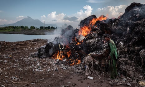 A man burns imported plastic waste at a dump in Mojokerto, in Indonesia’s East Java province