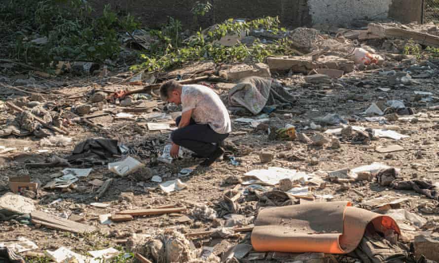A man examines pictures over the debris after shelling at a residential area in Mykolaiv, southern Ukraine.