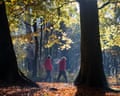 Two people walking in wooded area.