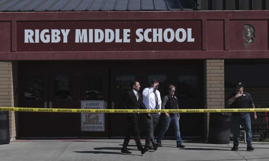 Officers leave Rigby middle school in Rigby, Idaho, after a shooting on 6 May. Two students and the school custodian were shot in the incident but all three survived. 
