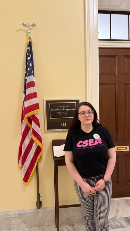 a woman outside a door next to a us flag