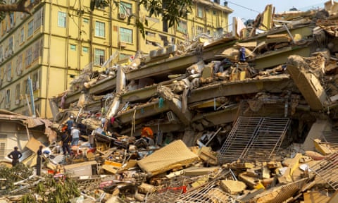Rescue personnel at the site of a building that collapsed in Mandalay.