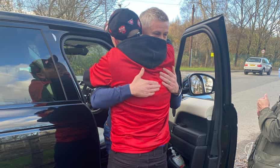 Ole Gunnar Solskjær hugs a Manchester United fan on his way out of the training ground.