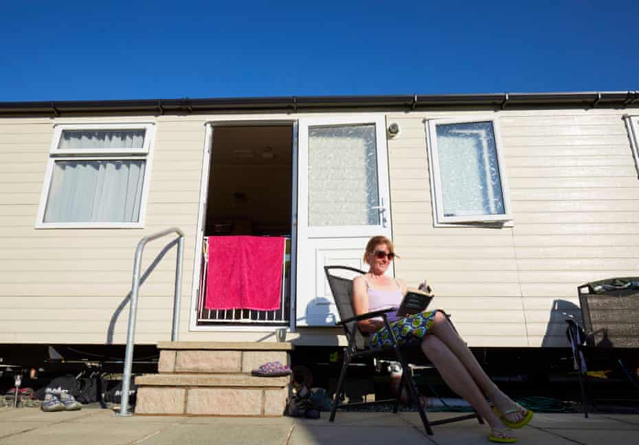 Carol Cunliffe reading outside her static caravan after spending a day paddle boarding on the Menai strait.