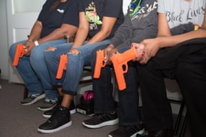 Participants hold fake guns in Marchelle Tigner’s sold-out class in Lawrenceville, Georgia.
