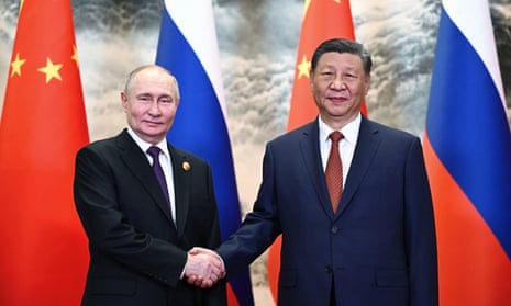 Russia's President Vladimir Putin (L) and China's President Xi Jinping shake hands prior to their talks in Beijing.