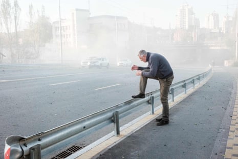 A man reacts surrounded by dust near the site of one of the drone attacks.