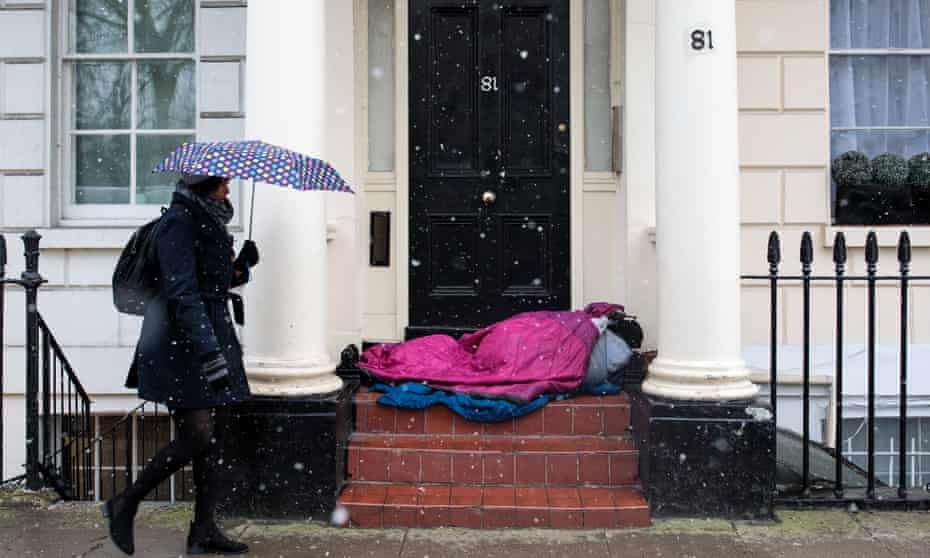 A homeless person sleeps on a doorstep in London during a snow in February this year.