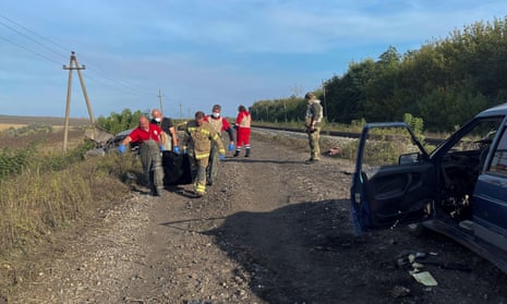 Volunteers carry the body a person from a civilian convoy, which Ukrainian State Security Service say was hit by a shelling from Russian troops amid Russia's attack on Ukraine, near the village of Kurylivka in Kharkiv region.