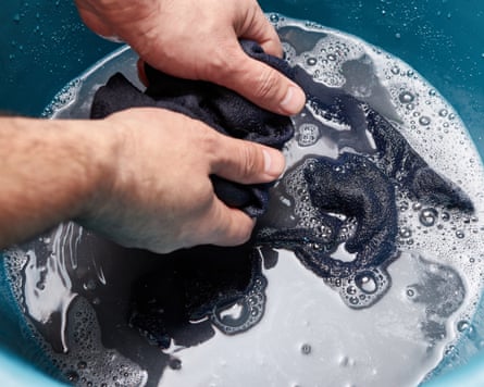 Socks are washed in a large bowl of soapy water.