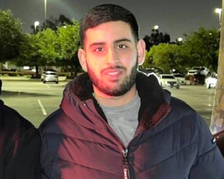 Sayfollah Musallet wearing a charcoal grey puffer jacket with the hood down in front of a parking lot background