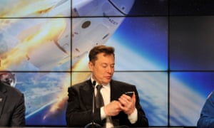 Elon Musk checking his phone during a SpaceX news conference in January 2020.