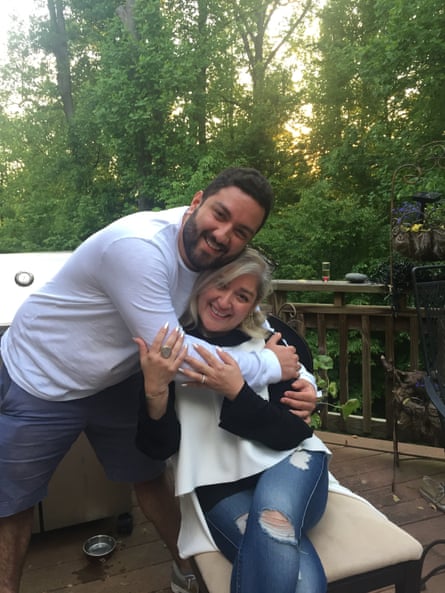 Bijan Ghaisar hugs Kelly Ghaisar as she sits on a chair in a garden
