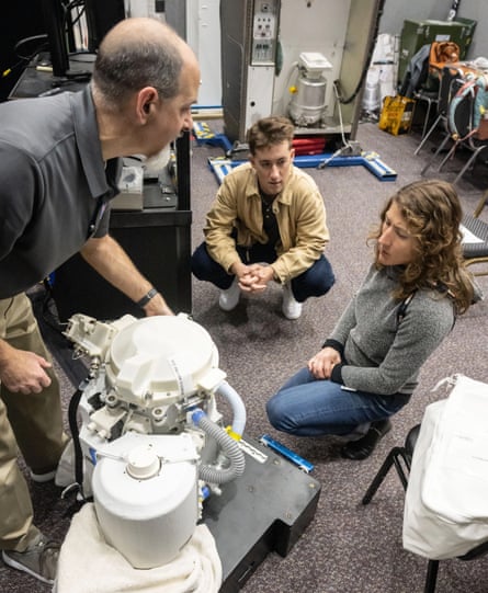 Christina Koch and two other people look at toilet apparatus.
