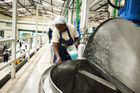 Hannah Kamau cleans a boiler after food has been removed, at the Food4Education kitchen in an industrial area of Nairobi