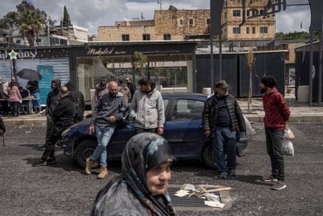 सहायता वितरण स्थल पर निवासी सड़क पर बातचीत कर रहे हैं