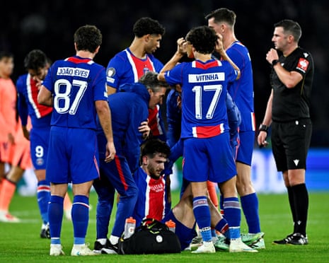 Khvicha Kvaratskhelia receives assistance after sustaining his knee injury against Barcelona.