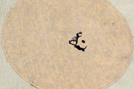 A child dribbles a basketball in a park in downtown Louisville, Kentucky, on 29 March. The city’s playgrounds are closed until May.