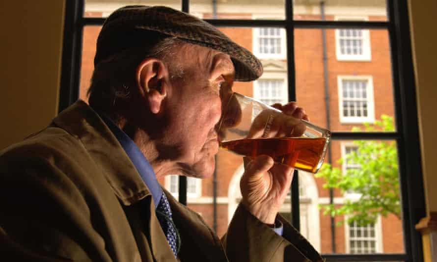 Old man drinks in a pub.