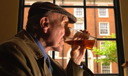 Old man drinks in a pub.