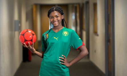 England’s united nations of football: 32 teams, one World Cup – and a lot of excited kids | World Cup 2022 9 Peace-Hillary Nsangou in a school corridor wearing a green Cameroon football shirt and holding a ball